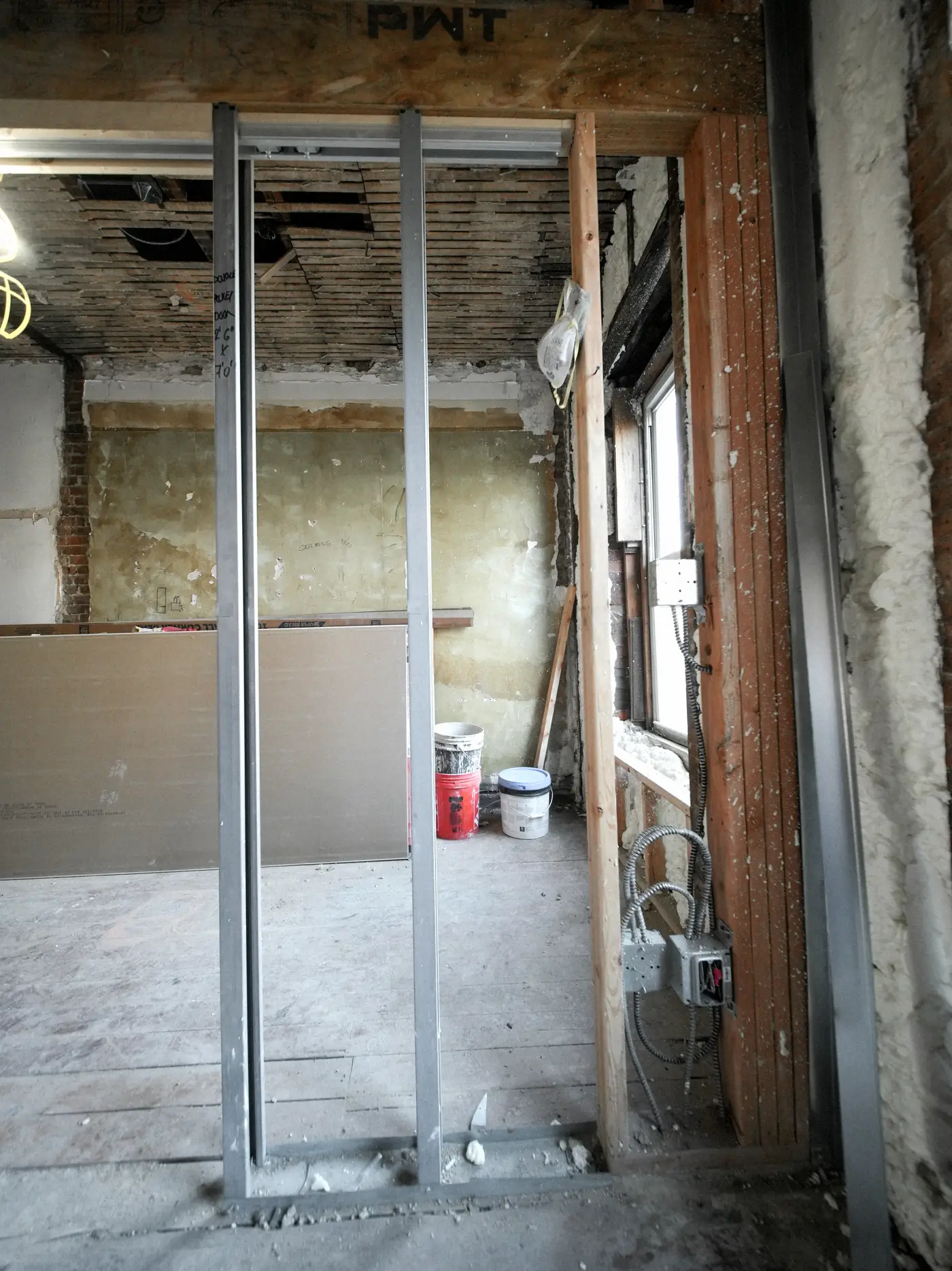 Cloison en cours de montage : montants métalliques, laine minérale et plaques de plâtre